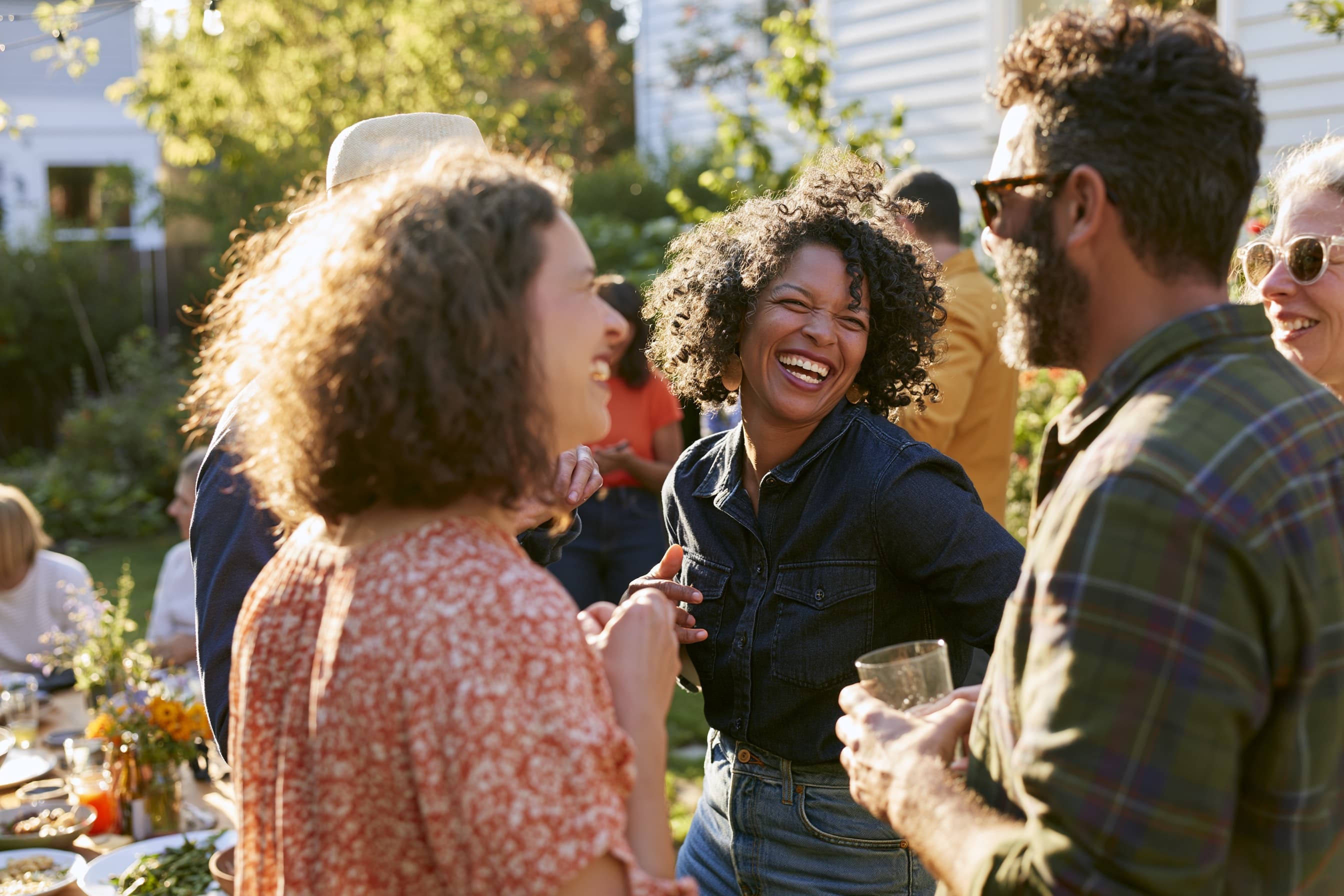 Friends laughing together around a backyard table